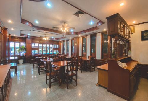 uma sala de jantar com mesas e cadeiras num restaurante em khampiane hotel em Ban Nongdouang