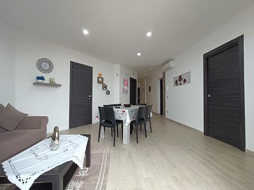 a living room with a couch and a table and chairs at Sciascia Apartment in Marina di Palma