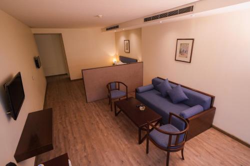 a living room with a blue couch and a table at Casa D'or Hotel in Beirut