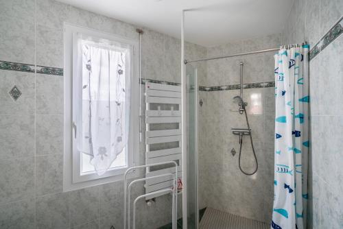 Jolie maison pour 6 personnes au Guilvinec في لو جويلفينيك: حمام مع دش ونافذة