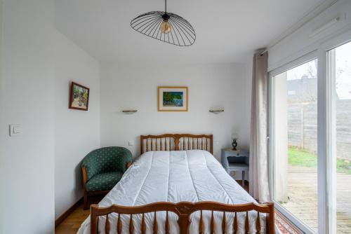 a bedroom with a bed and a large window at Jolie maison pour 6 personnes au Guilvinec in Le Guilvinec