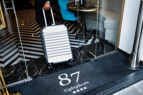 a white suitcase is sitting on a black floor at Hotel 87 eighty-seven - Maison d'Art Collection in Rome