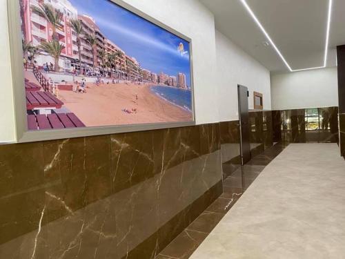 duży obraz plaży na ścianie w obiekcie Silvia luxury apartment w mieście Torrevieja