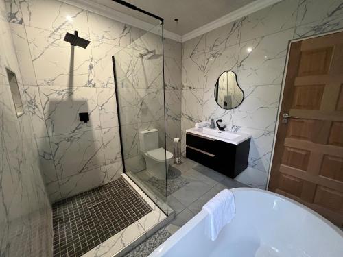 a bathroom with a shower and a toilet and a sink at Cheerful 3-bedroom home with backup power around Sandton in Sandton