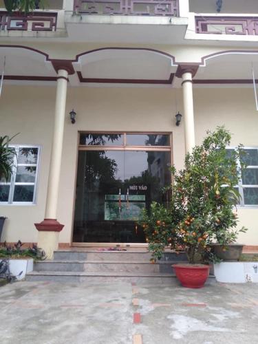 un edificio con una ventana y una planta delante en Nhà Nghỉ Bình Dân Xanh en Bắc Quang