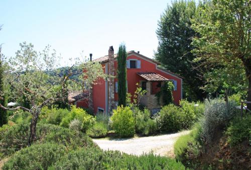 a red house in the middle of a garden at Il Vecchio Milipano in Montepulciano