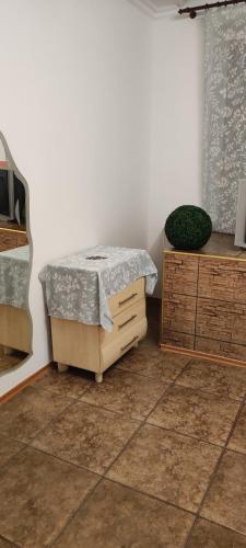 a bedroom with a bed and a wooden dresser at Гостевая комната in Chernivtsi