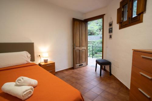 Schlafzimmer mit einem Bett und einer Tür zu einem Balkon in der Unterkunft Casa Rural El Mantillo in Hermigua