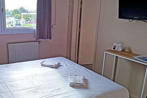 a room with a bed with two towels on it at The Originals Access, Hôtel les Iris, Berck-sur-Mer in Berck-sur-Mer