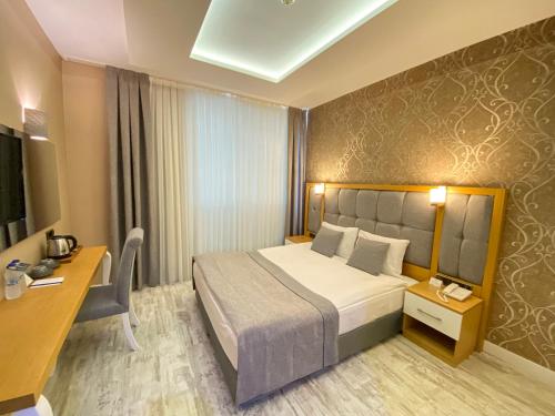 Habitación de hotel con cama y escritorio en Vista Family Hotel Konyaaltı, en Antalya