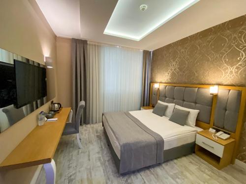 um quarto de hotel com uma cama e uma secretária em Vista Family Hotel Konyaaltı em Antalya
