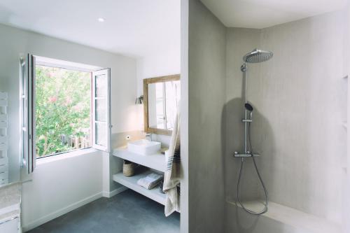 une salle de bain avec une douche et un lavabo et une fenêtre dans l'établissement Domaine L'Ermitage 5 * au coeur des terres basquo-landaises, à Hastingues