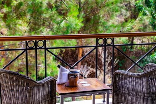 a table with wine glasses and a napkin on a balcony at Korineum Golf & Beach Resort in Kérynia