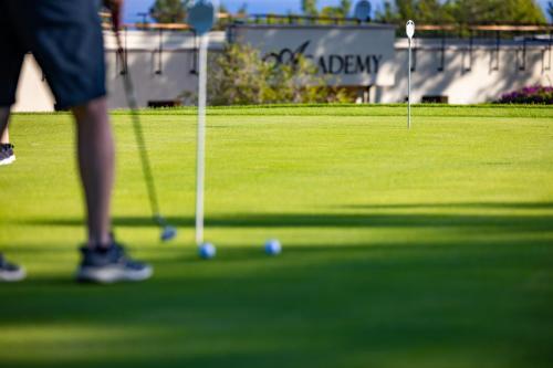a person is playing golf on a golf course at Korineum Golf & Beach Resort in Kérynia