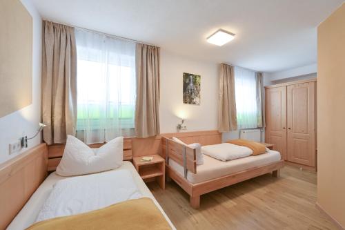 a bedroom with two beds and a window at Pension Freiheit in Pfronten