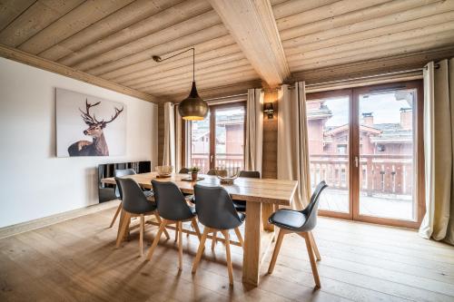 a dining room with a wooden table and chairs at Apartment Cervino Monriond Courchevel - by EMERALD STAY in Courchevel