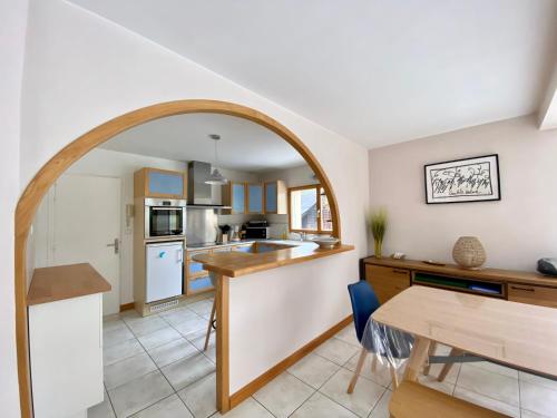 une cuisine et une salle à manger avec une arche au-dessus d'une table dans l'établissement Magnifique maison avec piscine à Beg Meil, à Fouesnant