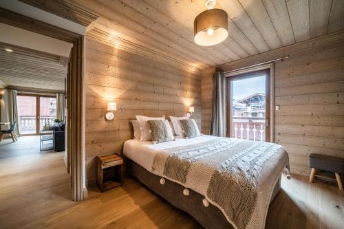 une chambre avec un lit et une grande fenêtre dans l'établissement Apartment Cervino Monriond Courchevel - by EMERALD STAY, à Courchevel
