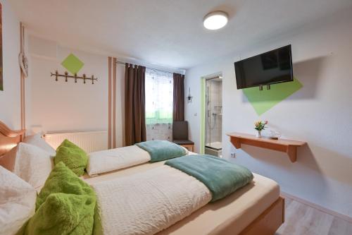 a bedroom with a bed and a flat screen tv at Pension Freiheit in Pfronten