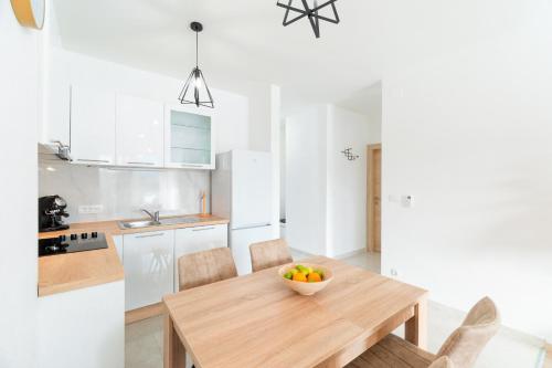 a kitchen with a wooden table with a bowl of fruit on it at Apartments & Rooms Fisherman's Luck in Vela Luka