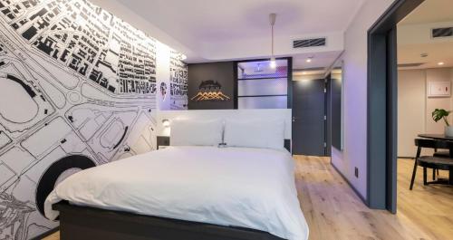 um quarto com uma cama grande e um mural de parede em ANEW Hotel Green Point Cape Town em Cidade do Cabo