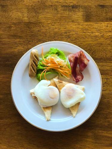 ペニダ島にあるKesari Glory Nusa Penida by GenuineHostの木製のテーブルの白皿