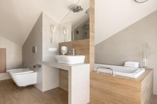 a bathroom with a sink and a tub and a toilet at Wilga in Ustroń