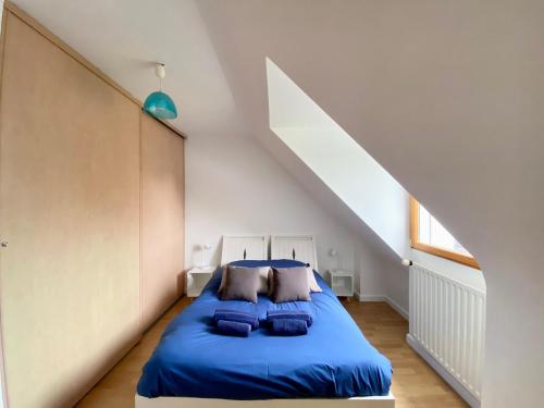 - une chambre mansardée avec un lit bleu dans l'établissement Magnifique maison avec piscine à Beg Meil, à Fouesnant