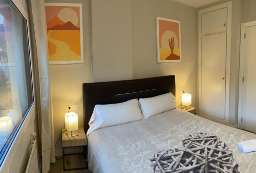 a bedroom with a large bed with two lamps at Renttarter Sans Espais in El Tarter
