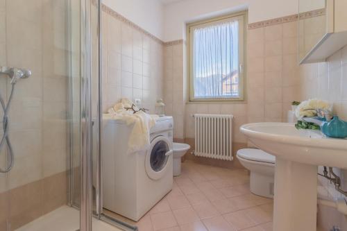 un bagno con lavatrice e lavandino di Casa Andrea Varenna a Perledo