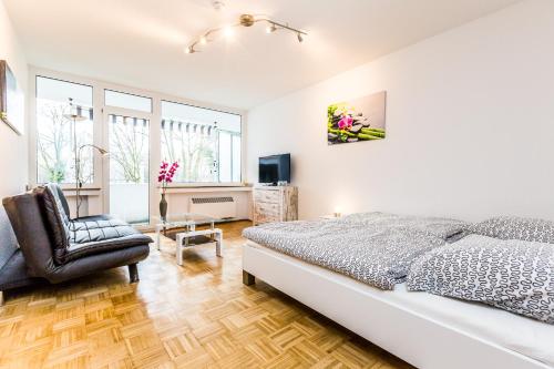 Work & Stay Apartment Monheim في مونهيم: غرفة نوم بيضاء بسرير وكرسي