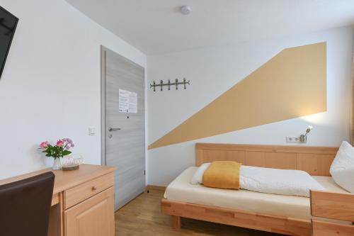 a bedroom with a bed and a desk and a staircase at Pension Freiheit in Pfronten