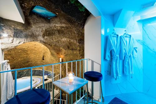 Habitación con paredes azules, mesa y taburetes en Il Confessionale, en Castelnuovo di Porto