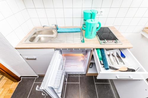 Work & Stay Apartment Monheim في مونهيم: مطبخ صغير مع حوض وثلاجة مفتوحة