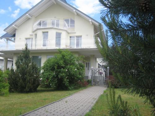 a white house with a porch and a driveway at Vila Elvina in Palanga