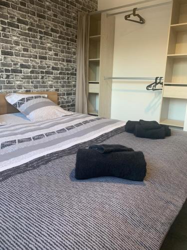 ein Schlafzimmer mit einem großen Bett mit Ziegelwand in der Unterkunft Lonora paddock in Créhange