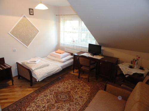 a room with a bed and a desk and a window at Dworek Jolanta in Biała Podlaska