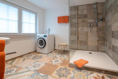 y baño con ducha y lavadora. en Franze´s Haus - mit Rhein- & Burgenblick, en Boppard