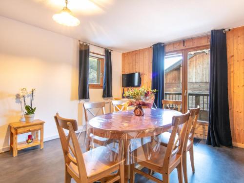 une salle à manger avec une table et des chaises en bois dans l'établissement Les Huskies - 50 - Appart spacieux 7 pers, à Saint-Sorlin-dʼArves