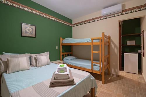 1 dormitorio con 2 literas y 1 cama con mesa en Pousada Rota das Cachoeiras, en Patrimônio São Sebastião