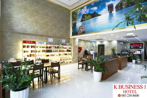 un restaurante con mesas y sillas en una tienda en K Business 1 Hotel My Dinh 미딩, en Hanói