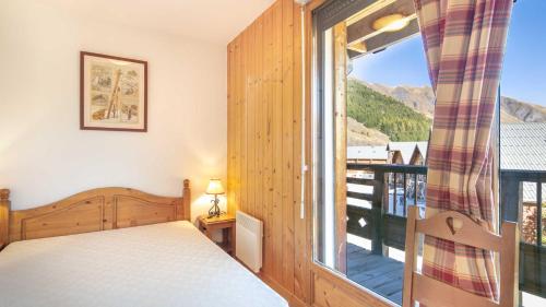 a bedroom with a bed and a large window at Les Marmottes- 38- Appart Vue montagne- 4 pers in Saint-Sorlin-dʼArves