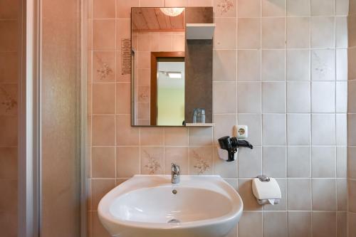 a bathroom with a sink and a mirror at Pension Freiheit in Pfronten