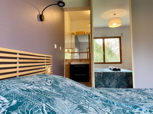 une chambre avec un grand lit et un miroir dans l'établissement Magnifique maison avec piscine à Beg Meil, à Fouesnant