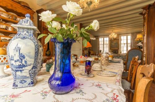 a table with two blue and white vases on it at La maison bleue in Arquian