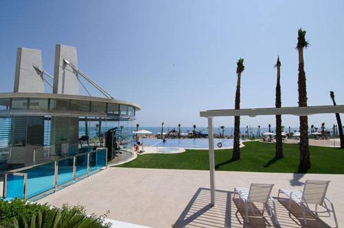 a patio with chairs and a pool and a building at Sea Senses Blue Ocean in Torrevieja