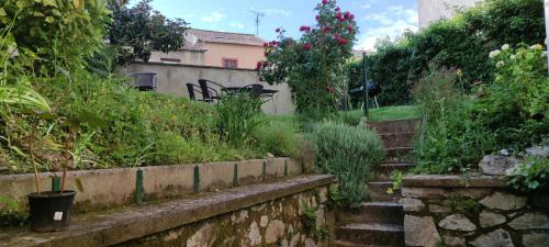 un giardino con scale e fiori e un edificio di Le sas de Fanny - chambres d'hôtes a Limoges