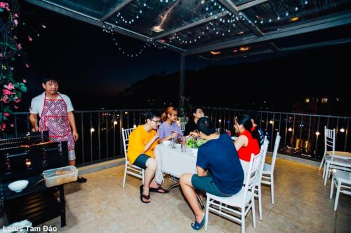 a group of people sitting around a table on a deck at Ros Hotel Tam Đảo in Tam Ðảo