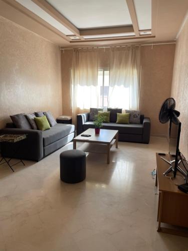a living room with two couches and a table at Airport to Comme à la maison 1 in Nouaseur
