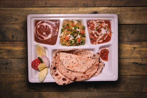 a tray of food with meat and different types of food at Hotel Sagar in Guwahati